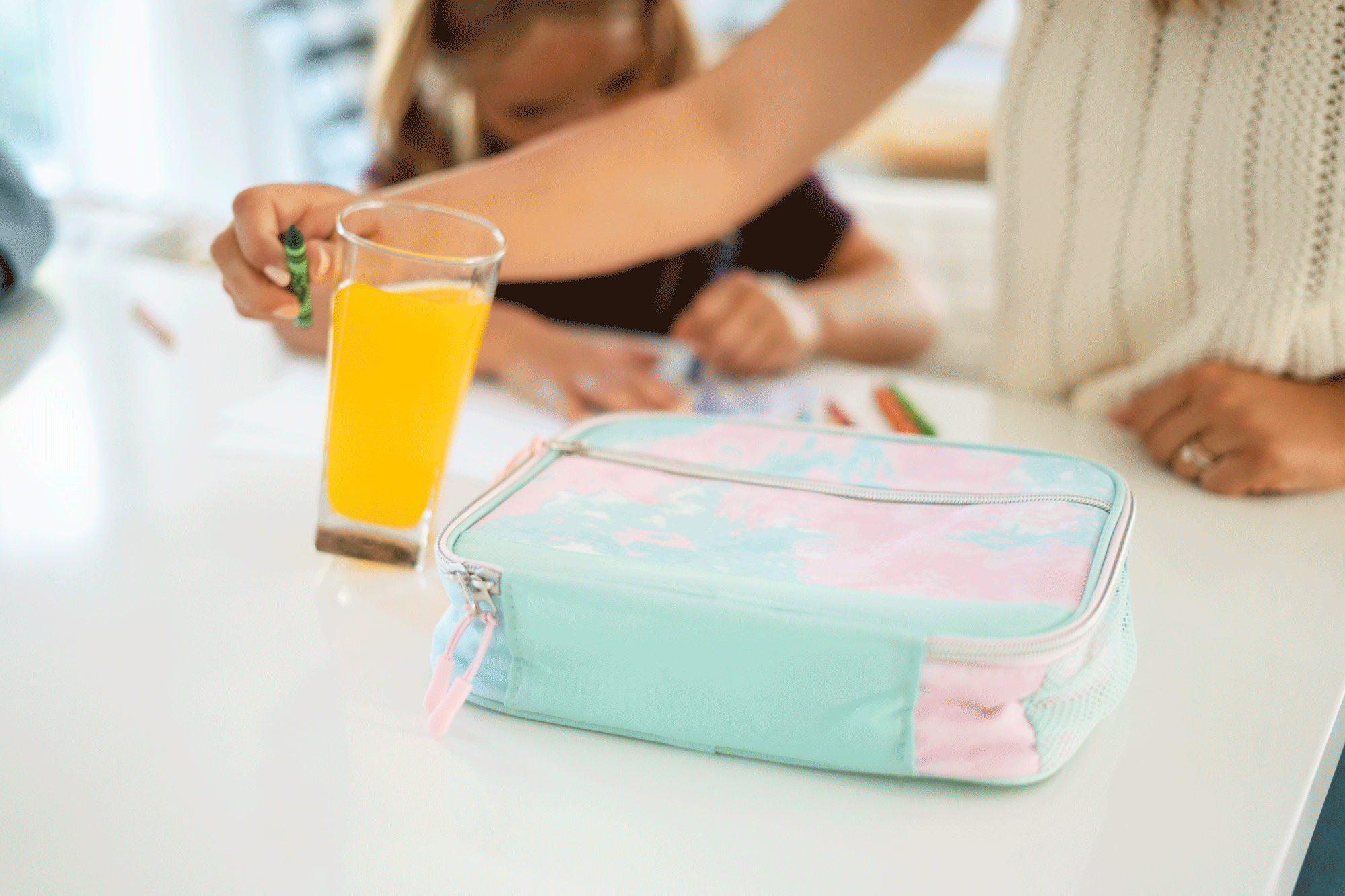 liquid beading up after mother spilling orange juice on daughters lunch box