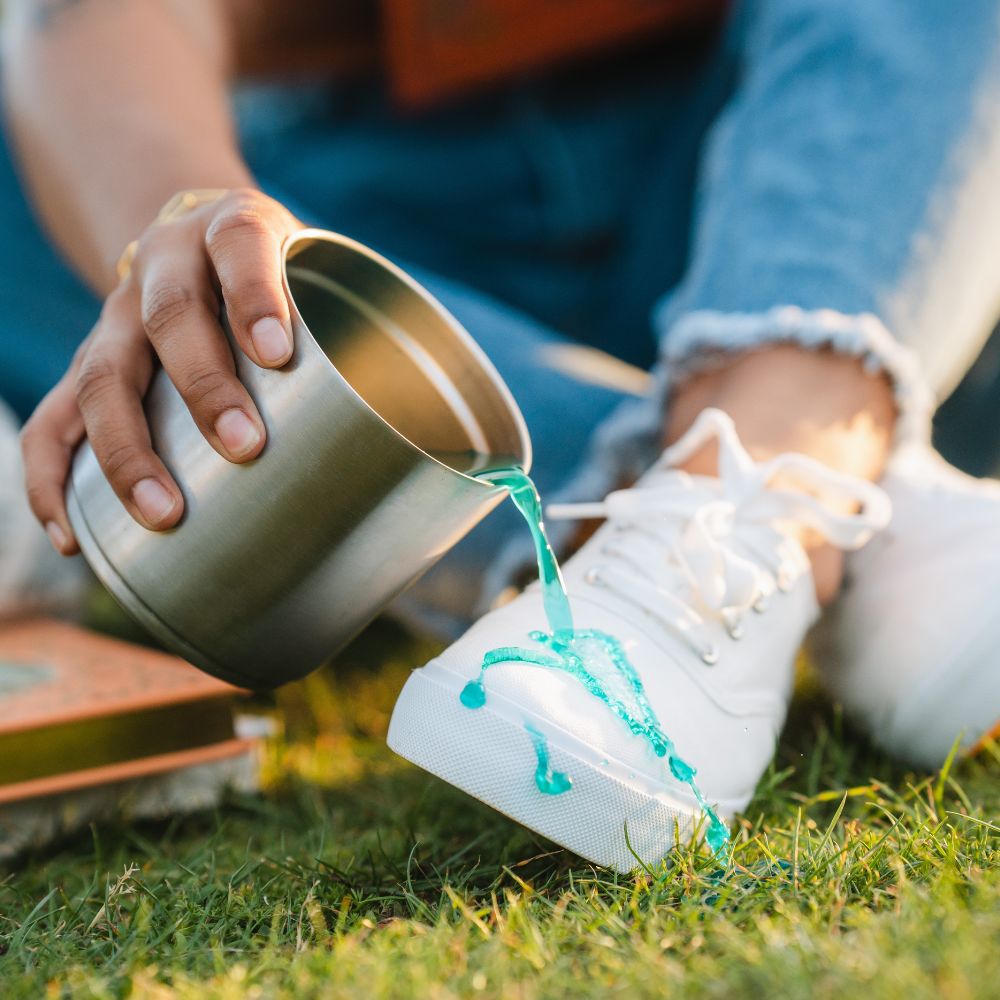 spilling drink on white shoe that is protected with ProofPlus