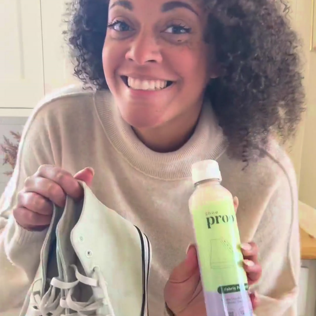 Woman holding shoes and Shoe Fabric Protector bottle