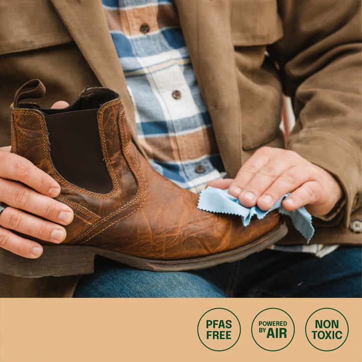 man conditioning and protecting his leather work boot, icons of PFAS free, powered by air and non toxic