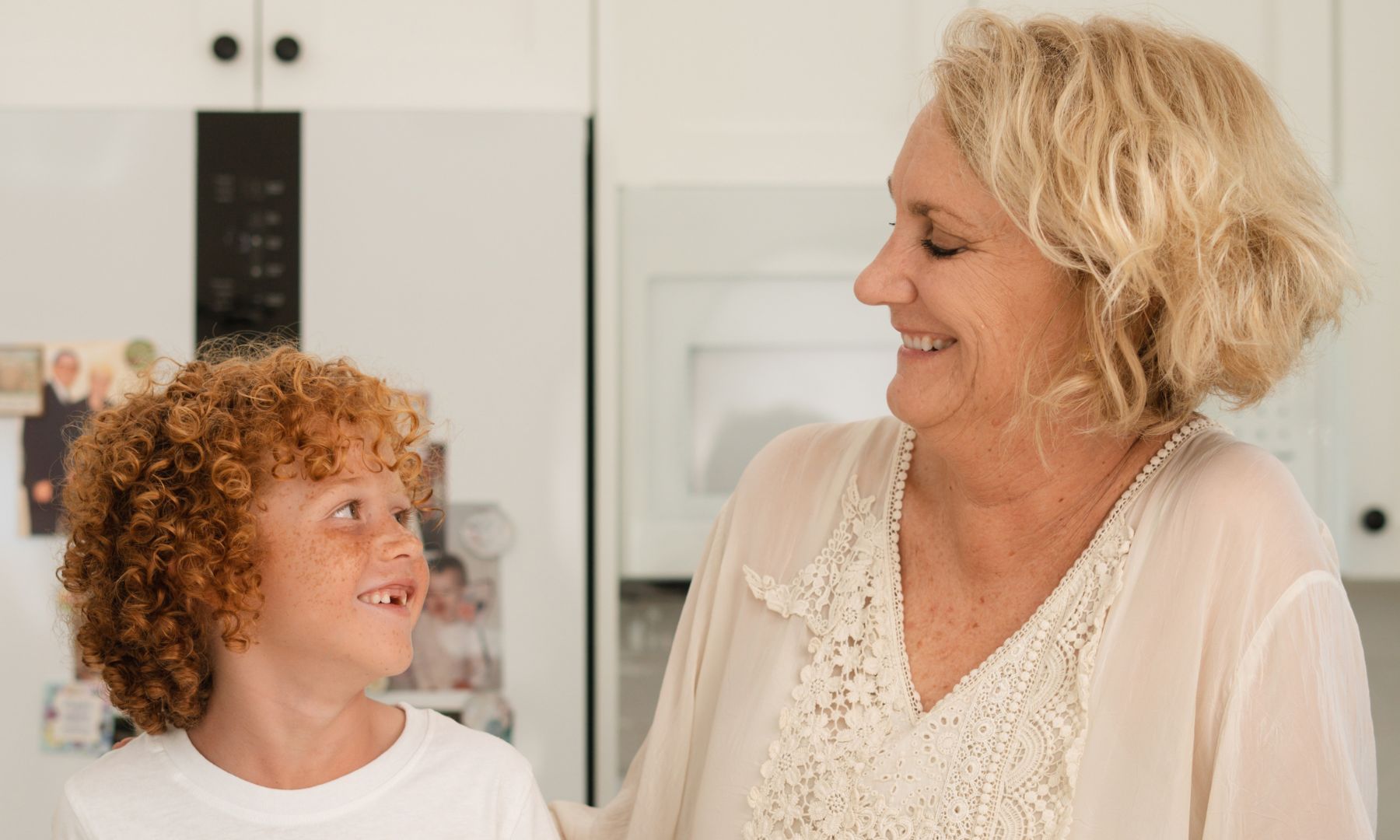 grandson and grandmother laughing at a baking mess they made