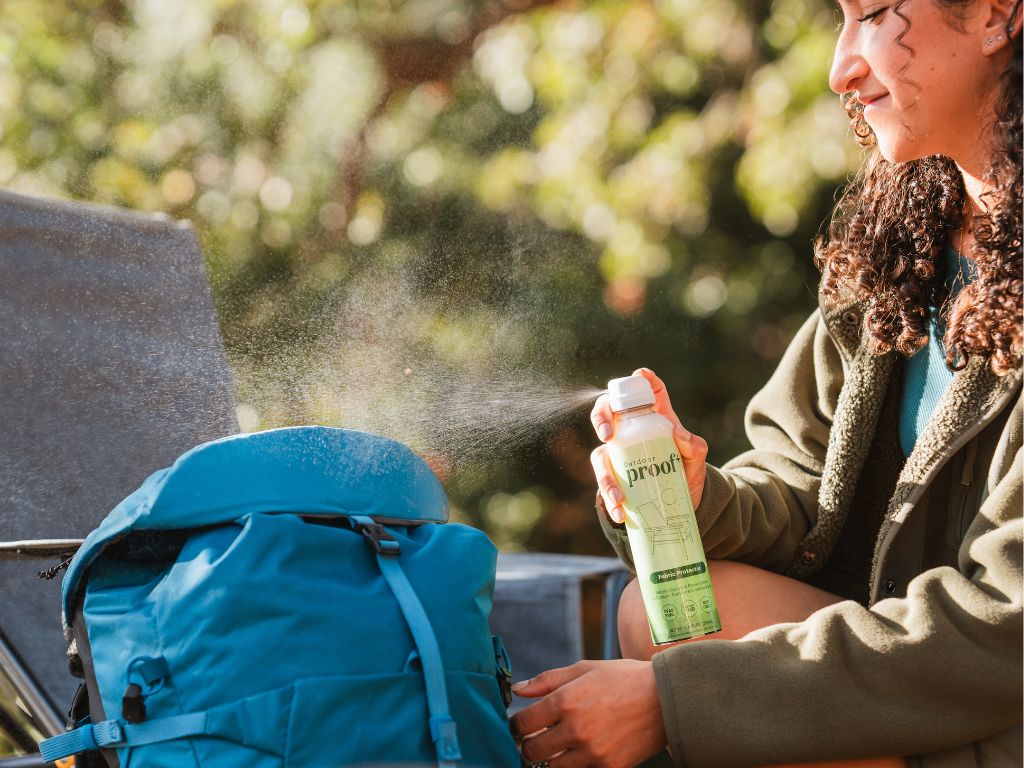 girl spraying outdoor backpack with ProofPlus Outdoor Fabric