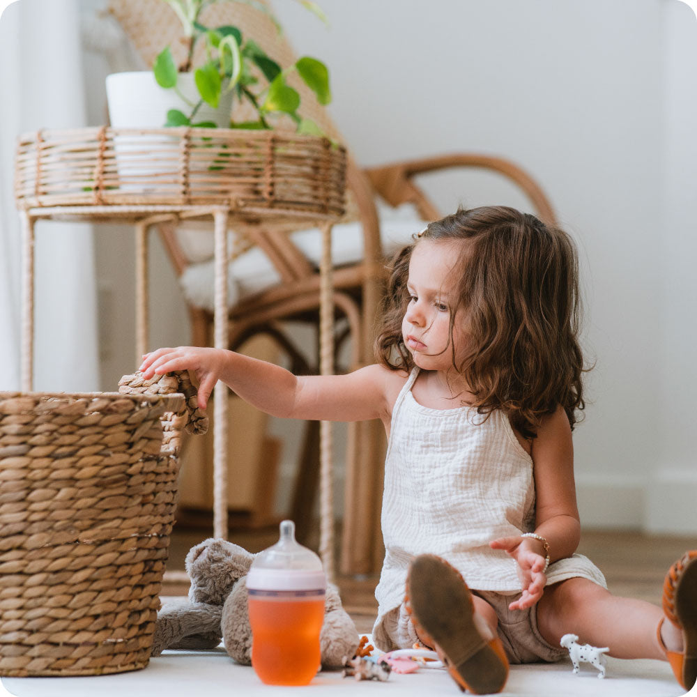 young girl playing with toy basket and stuffed bunny
