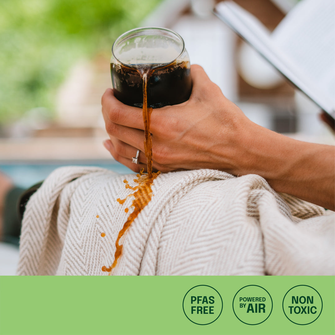coffee spilling on protected outdoor blanket with no stains and icons: pfas free, powered by air, non toxic