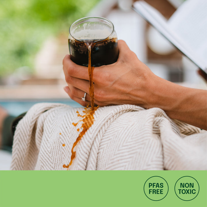 coffee spilling on protected outdoor blanket with no stains and icons: pfas free, non toxic